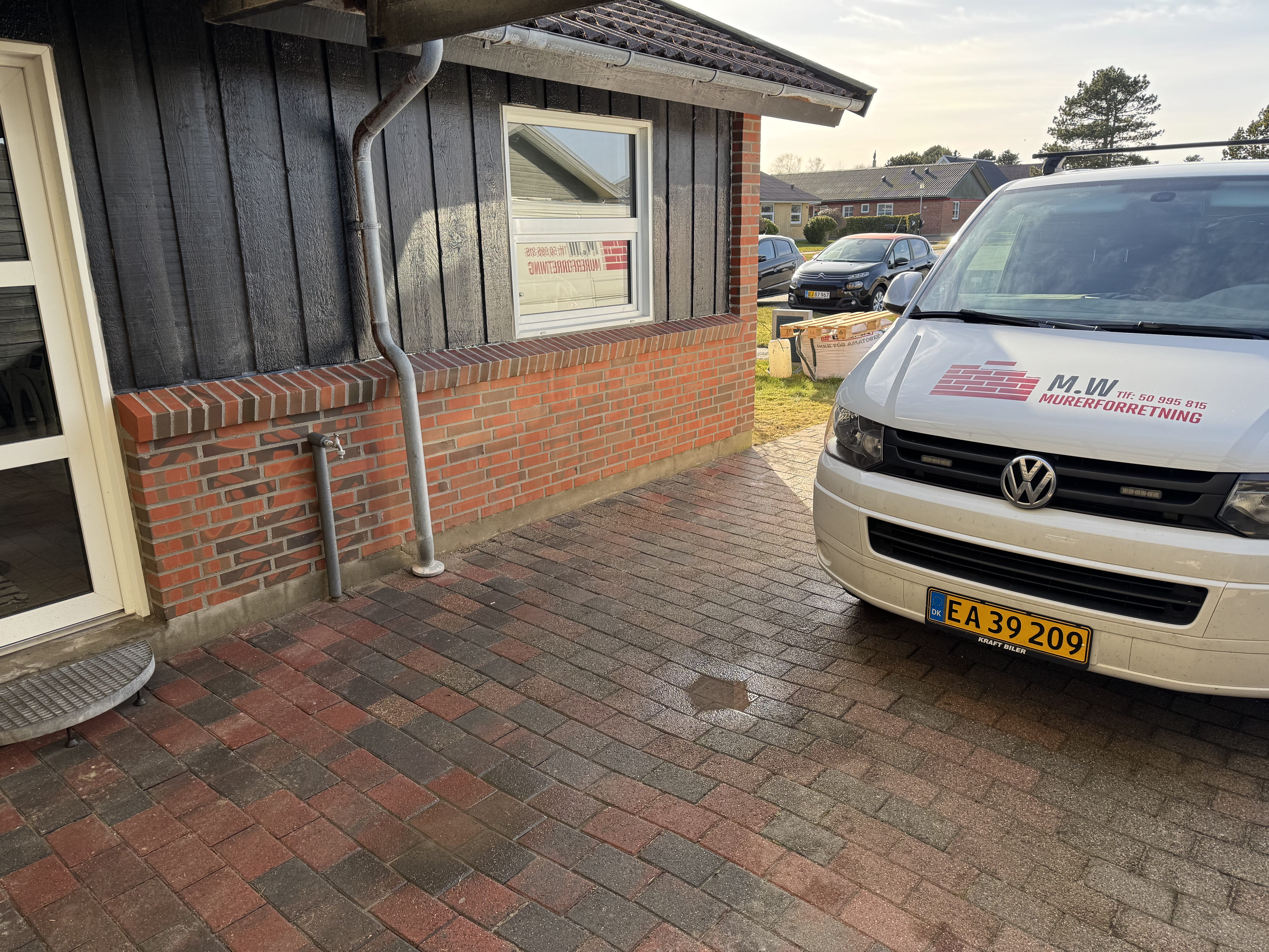 Murerfirma varevogn parkeret ved murstenshus